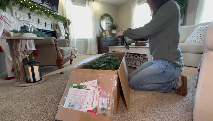 Fluff and decorate the Christmas tree, starting with the star and ribbon, then adding picks and ornaments in a diamond pattern.