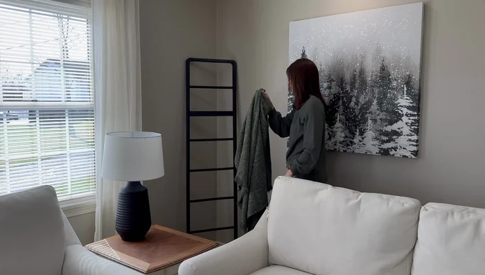 Style a corner end table with a grouping of three items: a pine tree in a hammered copper crock, a black deer, and a candle.