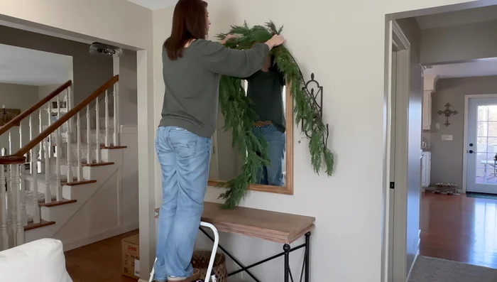 Drape a soft pine garland over a mirror, securing it by tucking branches behind the mirror.