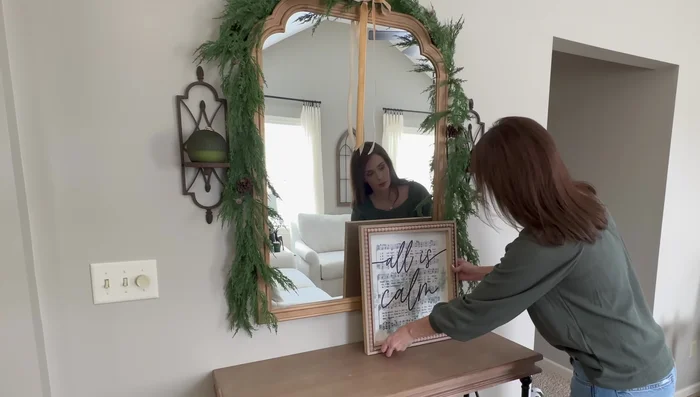 Decorate the bottom of the console table with a small pine tree in a copper canister, a small tray with bells, and a cozy blanket.