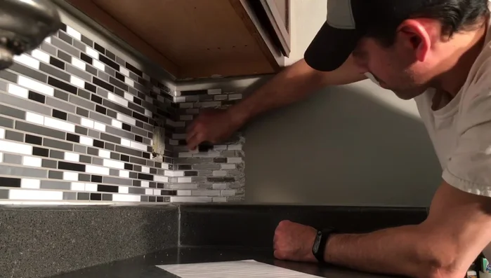 Apply any necessary filler strips to cover gaps between tiles and cabinets or other surfaces.