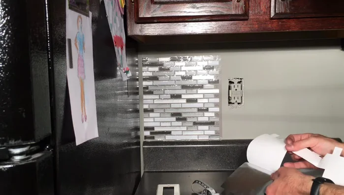 Remove the protective plastic film from the tiles after application.