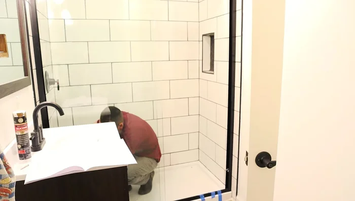 Caulk around the shower (inside and outside) for waterproofing.