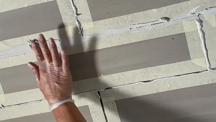 Smooth the grout using your finger (wearing a latex glove) to ensure even coverage and remove any excess. Wipe away excess grout immediately with a sponge or wipe.