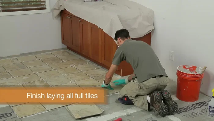 Finish laying all the full tiles in one quadrant, keeping the line straight, then finish the other three quadrants. Let the mortar harden for 24 hours.