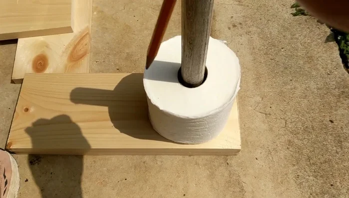 Drill holes in side boards. Mark and drill holes in the side boards to accommodate the dowel, ensuring proper alignment with the toilet paper rolls.