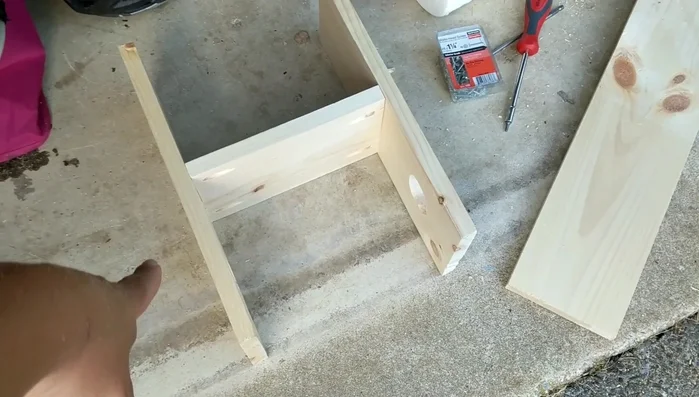 Assemble the main structure. Attach the back support to the side boards. The presenter initially attempted pocket holes but recommends screwing from the outside for better results.