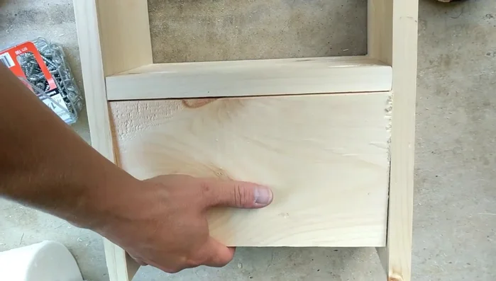 Attach the front support. Cut and attach the front support, adjusting its height as needed. The presenter chooses to leave one end slightly protruding for aesthetic reasons.