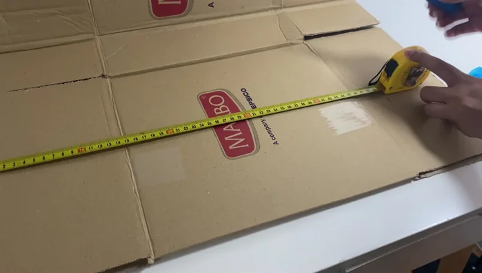 Apply adhesive paper to cover the cardboard.