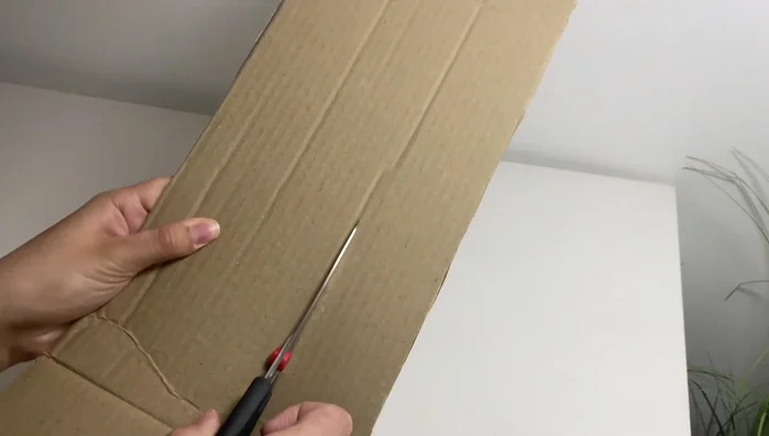 Apply adhesive paper to cover the cardboard.