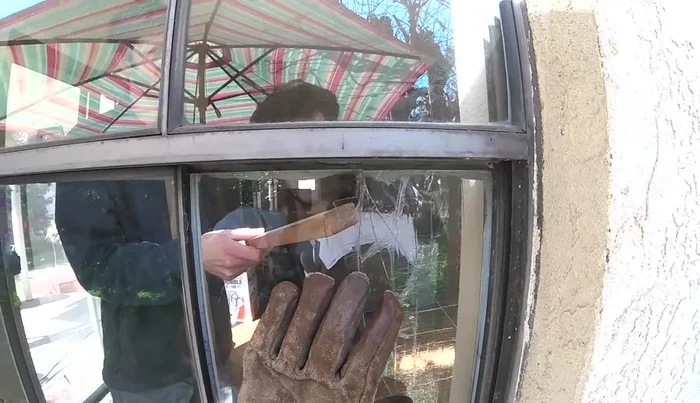 Carefully remove the broken glass pane using a stick or putty knife.