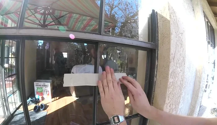 Apply tape to the new glass pane to hold it in place while the sealant dries.