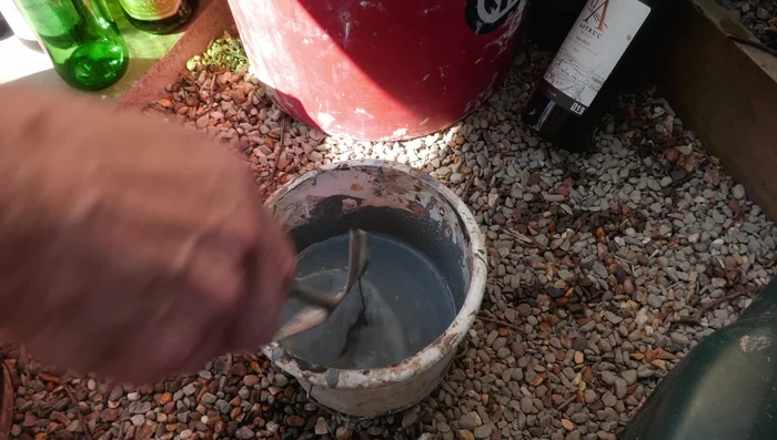 Level the sub-base. Mix and apply a fresh batch of bedding mortar using the cement mixer, making sure to add water gradually (this step highlights issues with an old, damaged cement mixer).