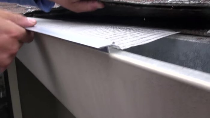 Fasten three self-tapping screws for each 4' section using the line guide on the aluminum extrusion as a reference. The screw's drill bit will go through the aluminum and gutter.