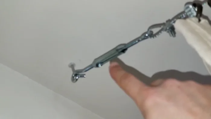 Adjust the wire tension using the hooks' mechanism to create a taut line.