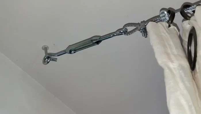 Adjust the wire tension using the hooks' mechanism to create a taut line.