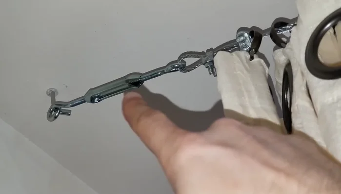 Adjust the wire tension using the hooks' mechanism to create a taut line.