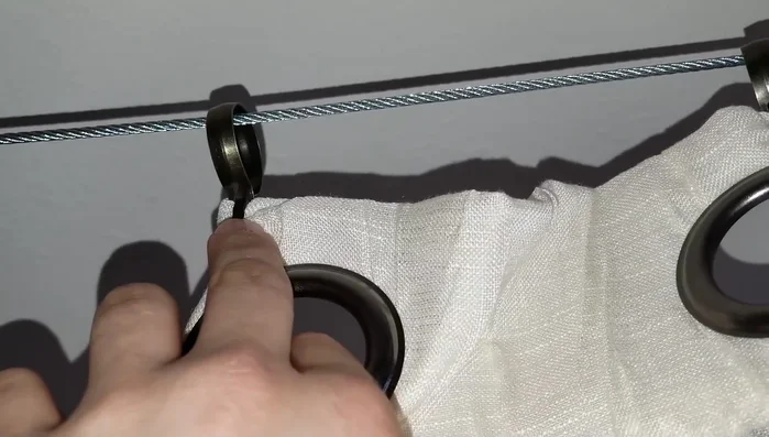 Attach the netting to the wire using the clips, ensuring even spacing and sufficient overlap to prevent gaps.