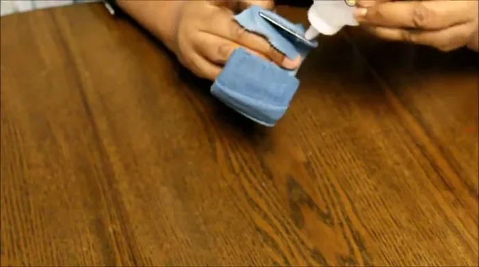 Apply glue to the remaining edge to secure the denim to the inside of the bracelet.