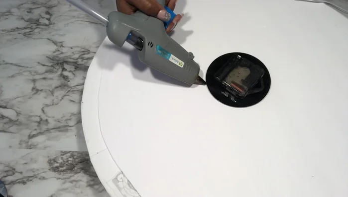 Create Roman numerals (Method 1): Use flexible mirror sheets or mirror reflective paper on poster board to cut out Roman numerals and glue them onto the clock.
