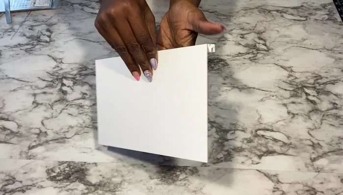 Create Roman numerals (Method 1): Use flexible mirror sheets or mirror reflective paper on poster board to cut out Roman numerals and glue them onto the clock.