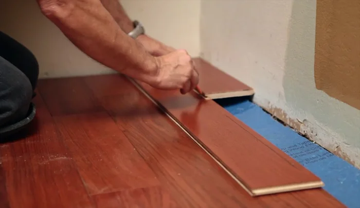 Cut and install the last row, maintaining expansion gaps. Use a pry bar to snug the floor tightly.