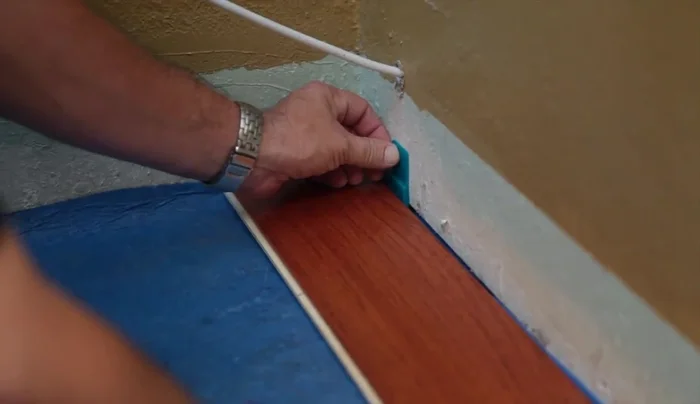 Use blue painter's tape to hold the floor in place while the glue cures (Do not use regular masking tape).