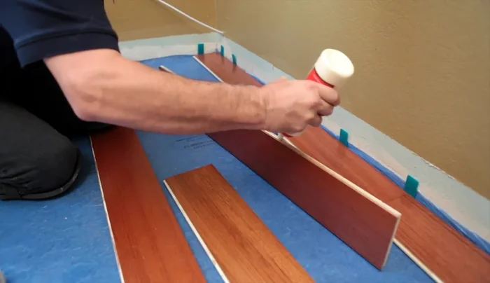 Use blue painter's tape to hold the floor in place while the glue cures (Do not use regular masking tape).