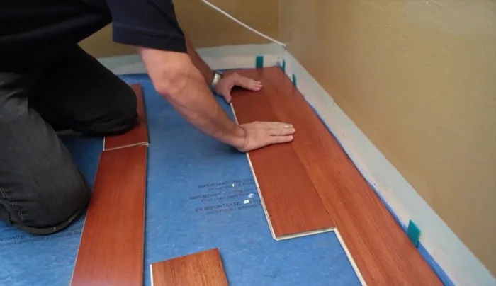 Use blue painter's tape to hold the floor in place while the glue cures (Do not use regular masking tape).