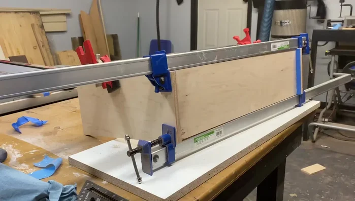 Apply walnut edge banding to the front, using glue and clamps. Flush cut and plane to achieve a smooth finish.