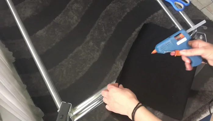 Place the fabric liner inside the popsicle stick box, and trim the excess corners diagonally before gluing the fabric to the inside of the box.