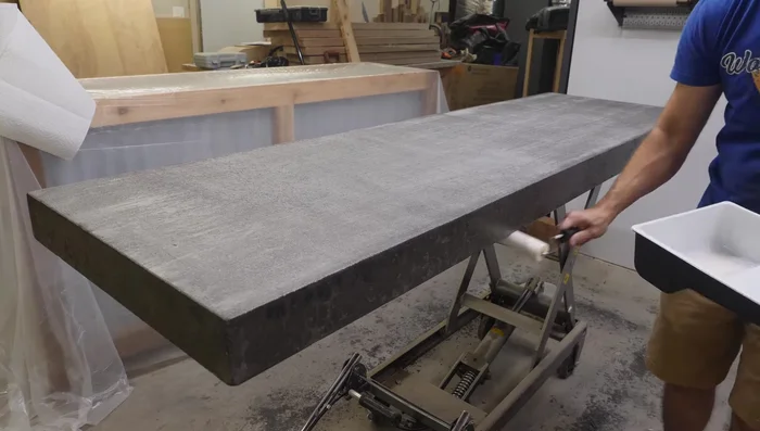 Attach the concrete countertop to the bar base using construction adhesive.
