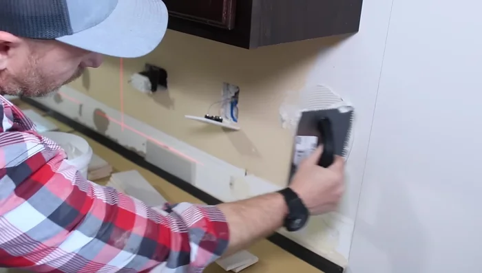 Cut tiles around outlets, stopping at the drywall.