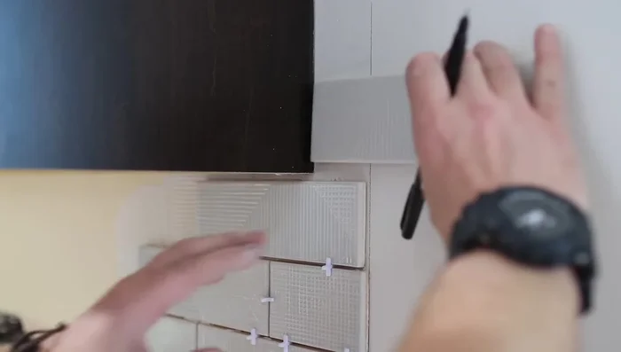 Cut tiles around outlets, stopping at the drywall.