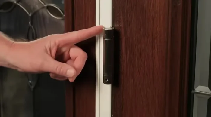 Identify the spring-loaded hinge (usually the middle hinge, but could be the bottom depending on door configuration).