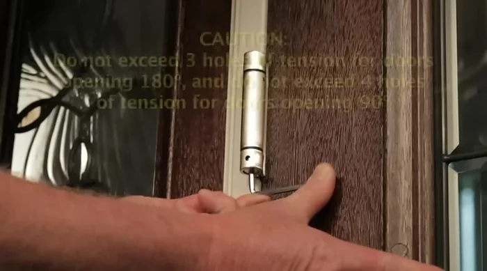 Adjust to minimum tension needed to close and latch the door. Too much tension reduces hinge lifespan.