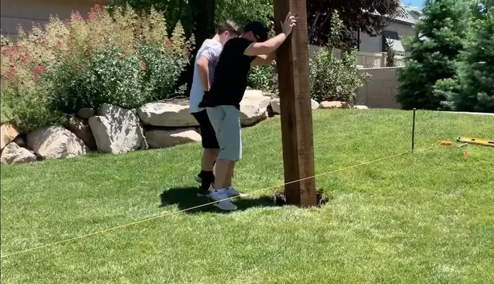 Measure and level the second post to match the first post's height. Ensure the distance between the inside of the posts is 14 feet 2 inches.