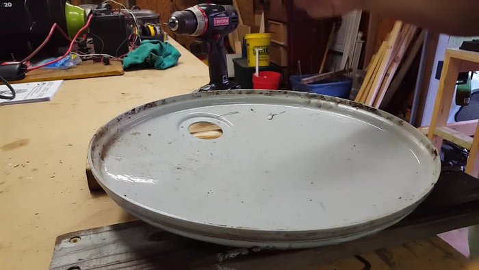 Acquire materials: Use an old 30-gallon drum lid and the base of a broken Shepherd's hook clock.