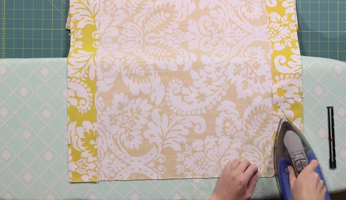 Miter corners: For each short side, fold the right corner up at a 45° angle, press; repeat for the left corner. Then fold the entire edge up 3 inches, press and pin.