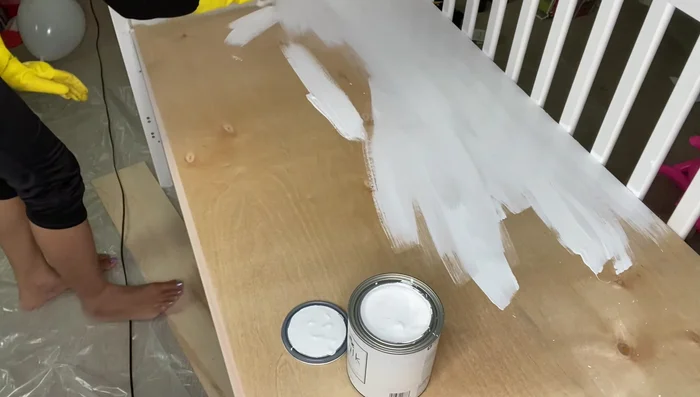 Paint the desk with two to three coats of non-toxic white chalk paint and let it dry completely.