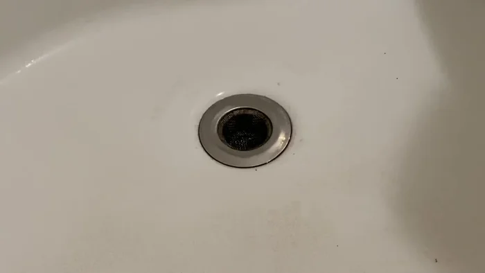 Close the drain or cover with a towel.