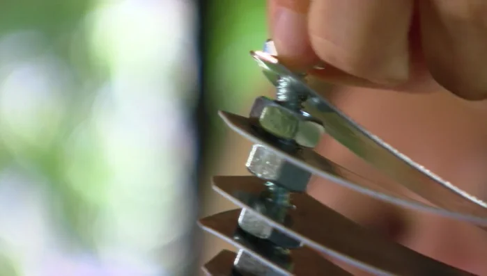 Add the top strap to form a spiral shape, secure with the final small nut.