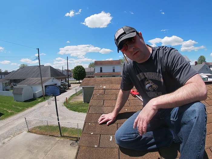 Inspect the roof for damaged shingles. Identify the shingles that have lifted or are damaged.