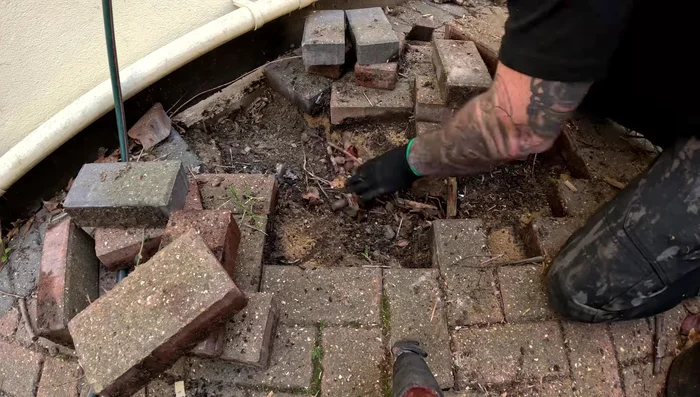 For severely sunken areas with significant gaps, consider adding a sub-base of bricks before adding sand and blocks.