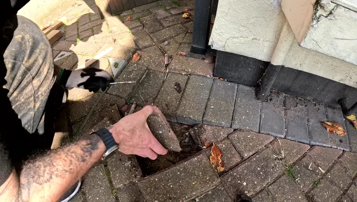 Scrape off debris and sand from the removed blocks.