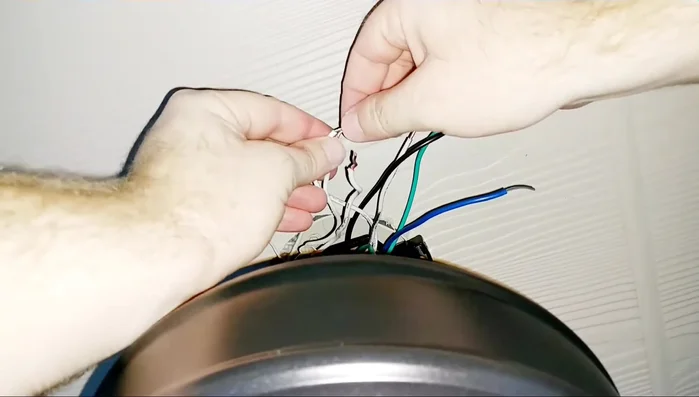 Wire the fan. Connect the wires: white to white, black to black, blue (fan) to red (light), and all ground wires together. Use wire nuts, twisting clockwise. Push wires firmly into wire nuts.