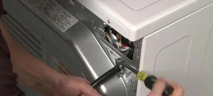 Remove the screws from the strain relief and pull the relief out of the rear panel.