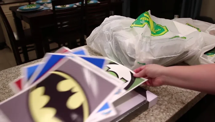 Make superhero artwork using dollar store picture frames and free printable logos. Arrange them on the wall using painter's tape and command strips for easy adjustments.