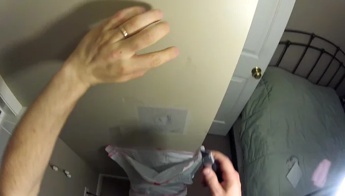 Apply a drywall patch, ensuring it's centered and flush with the wall. Gently press to ensure proper adhesion.