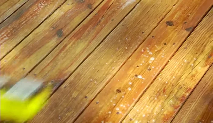 Scrub the cleaner into the wood with a synthetic bristle brush, let it sit for 10-15 minutes, and then rinse thoroughly.